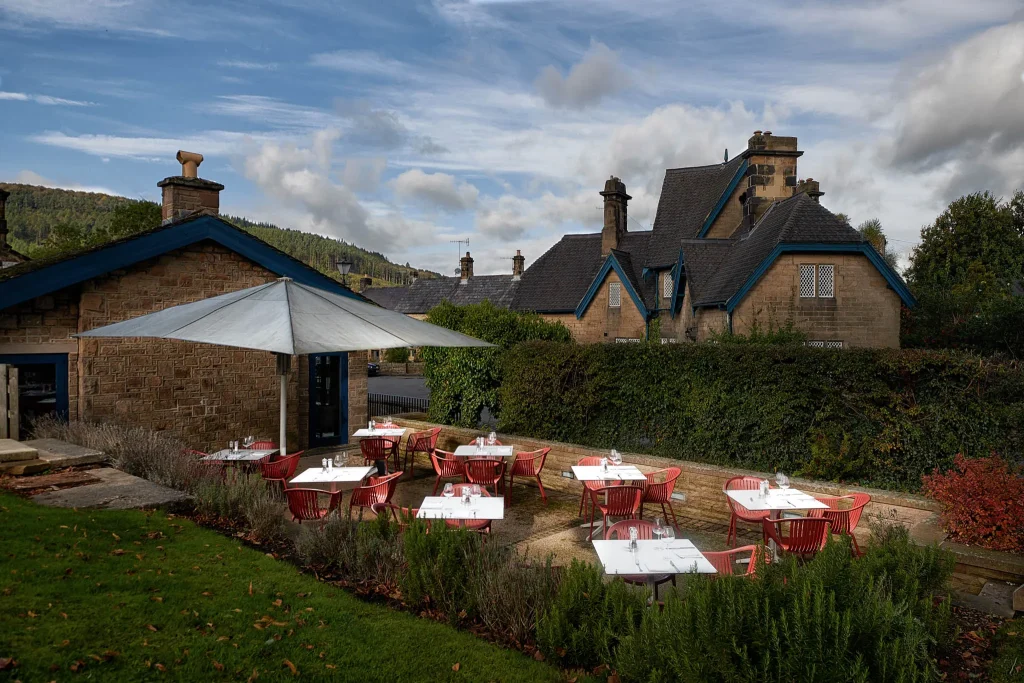A picture of the Devonshire's Arms garden, with tables/chairs and a parasol. 