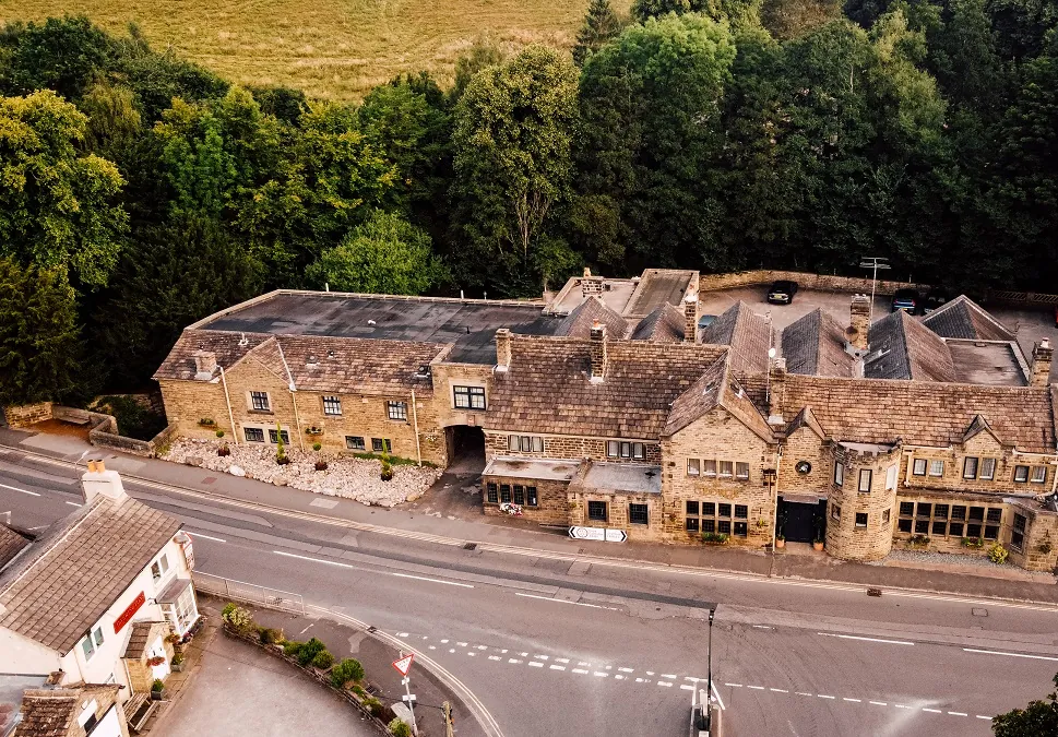 Aerial picture of The George - a very large building with lots of trees behind.